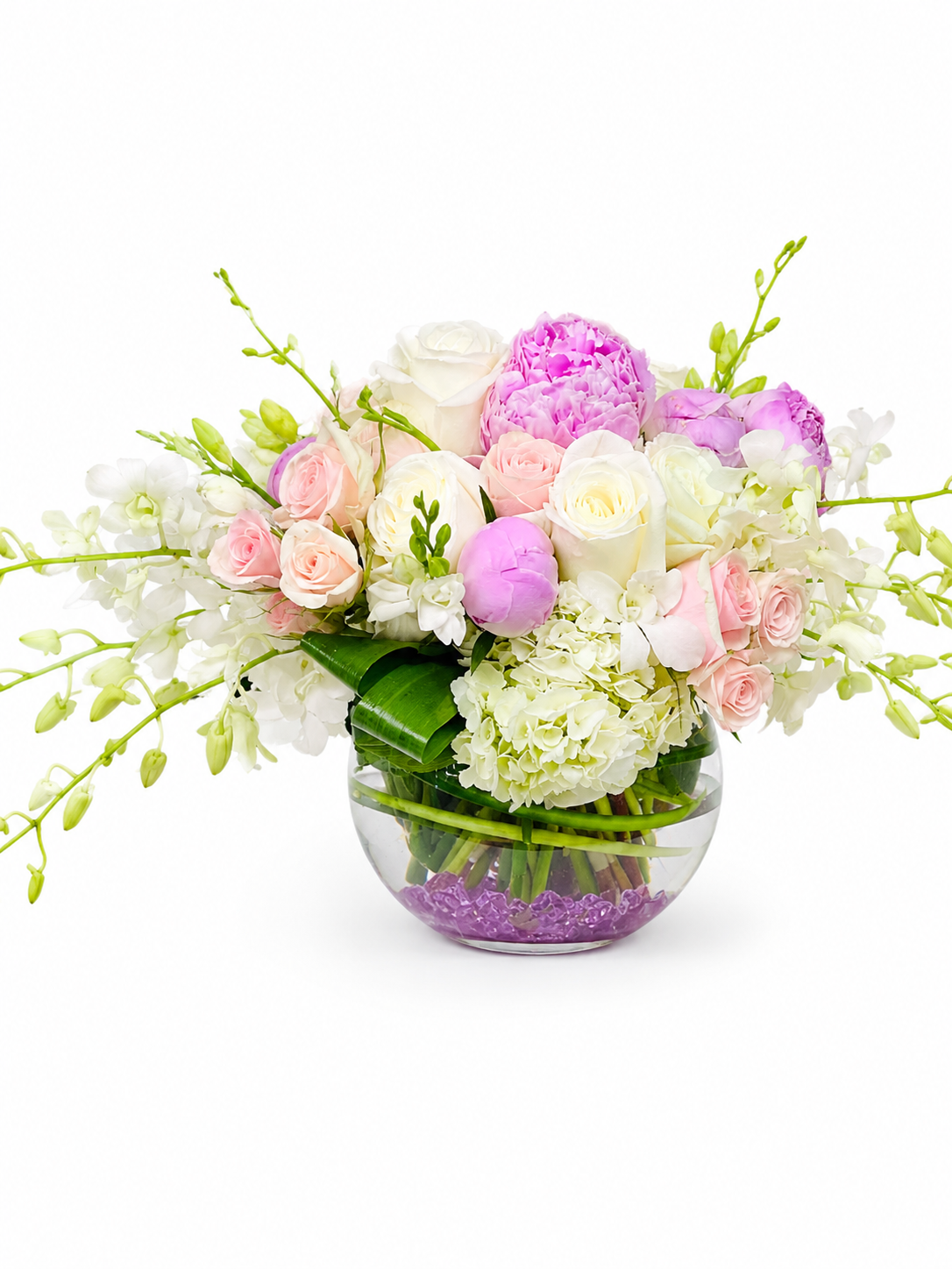 Floral arrangement with pink, white, and purple flowers in a clear vase on a white background