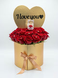Gold heart-shaped box with fresh red roses and a ring box, featuring 'I love you' text.